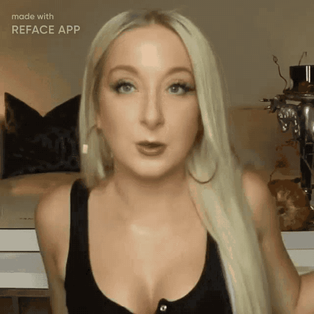 a woman with blonde hair is wearing a black tank top .