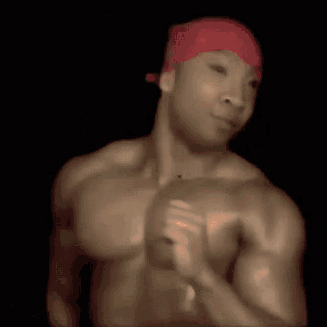 a man with a red hat on his head is kneeling down in a dark room .