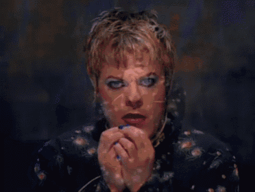 a woman with blonde hair and red lipstick is making a face