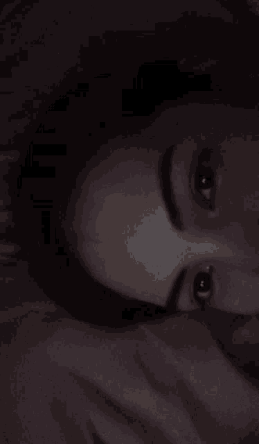 a close up of a woman 's face with a blanket covering her face