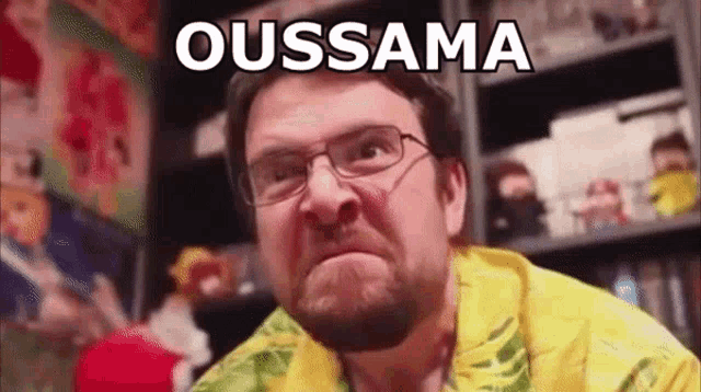 a man with glasses and a beard is making a funny face with the word ousama written on his face .
