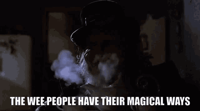 a man smoking a cigarette with the words " the wee people have their magical ways " next to him