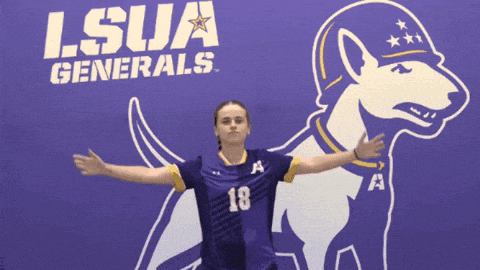 a girl stands in front of a lsua generals sign