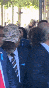 a man in a suit and tie stands in a crowd