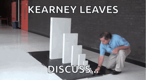 a man is kneeling down in front of a stack of dominoes with the caption " kearney leaves discuss ... "