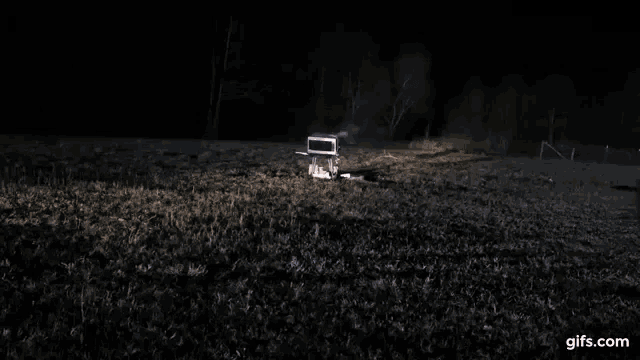 a light is shining on a dark field at night