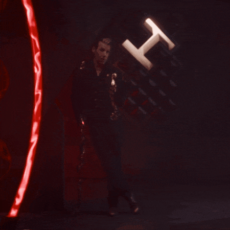 a man is standing in a dark room with a red light behind him that says h