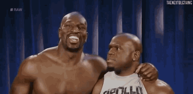 two bald men are hugging each other and smiling .