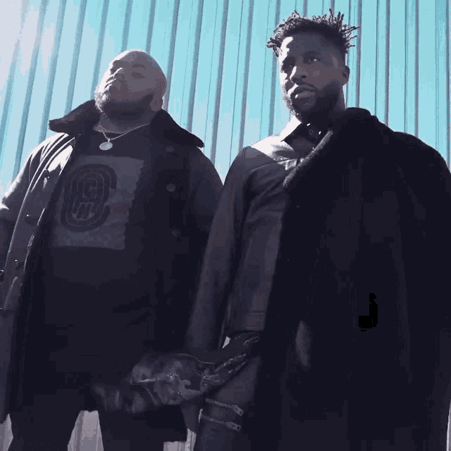 two men are standing next to each other with one wearing a shirt that says ' gs ' on it