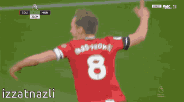 a group of soccer players celebrate a goal with the words izzatnazli in the lower right corner