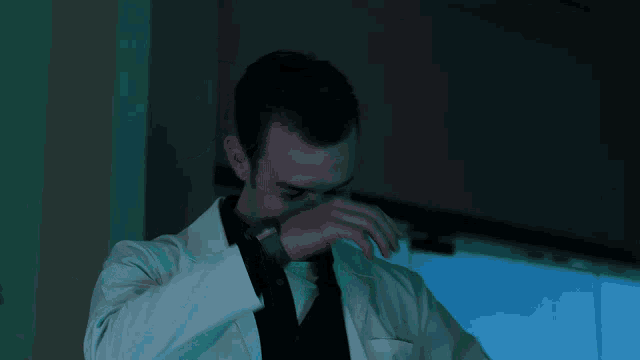 a man in a lab coat is talking on a phone
