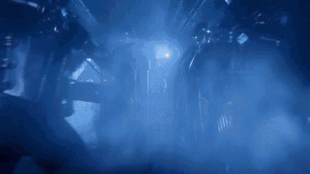 a dark room with a blue light shining through a doorway