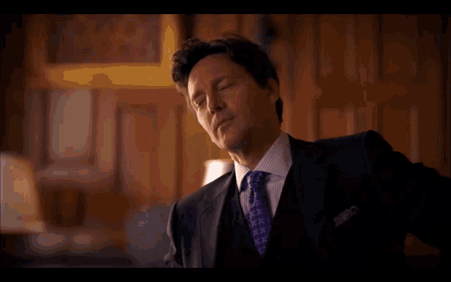 a man in a suit and tie is looking down