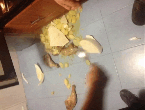 a person is cutting potatoes on the floor with a knife