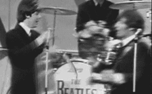 a black and white photo of the beatles playing drums .