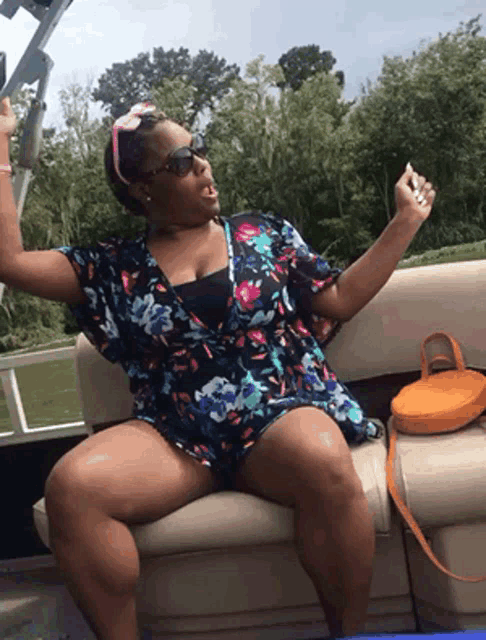 a woman is sitting on a boat taking a picture with her phone