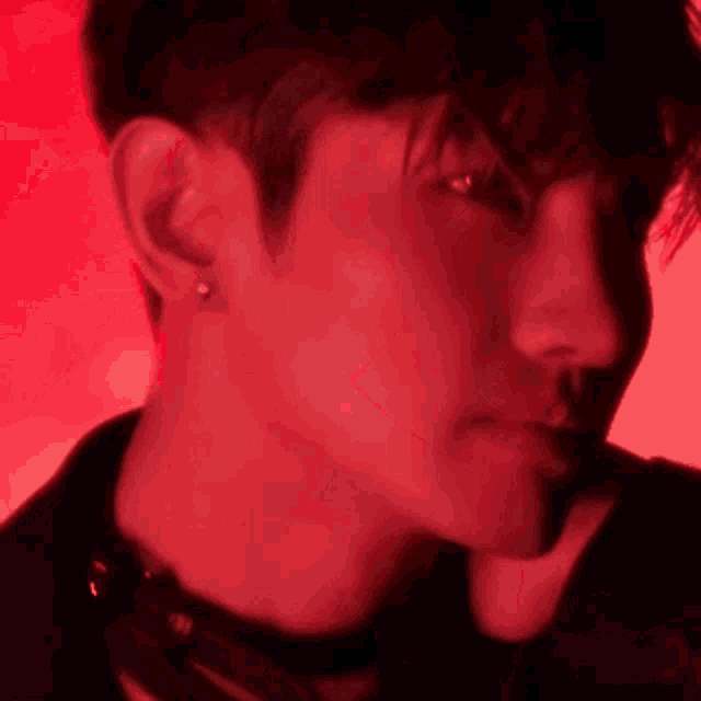 a close up of a person 's face in a red light .