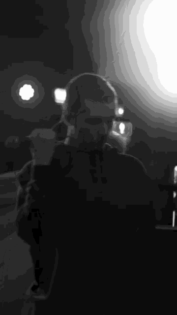 a man is singing into a microphone in a black and white photo .