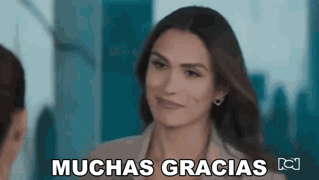 a woman is smiling while talking to another woman and the words muchas gracias are above her