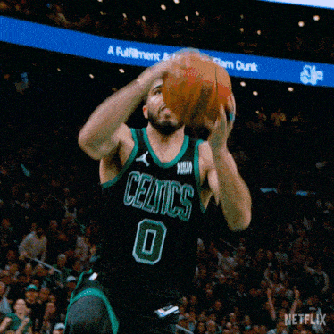 a basketball player for the celtics jumps in the air to dunk the ball