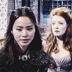 two women are standing next to each other and one of them is wearing a purple dress