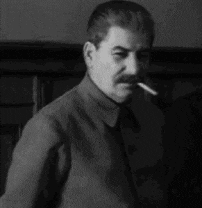 a man with a mustache is smoking a cigarette in a black and white photo with russian writing on it .