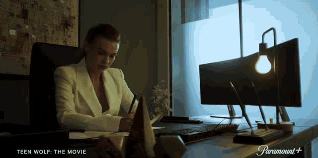 a woman sits at a desk in front of a computer with paramount + written on the bottom