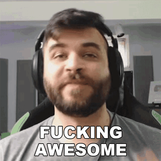 a man with a beard is wearing headphones and says fucking awesome