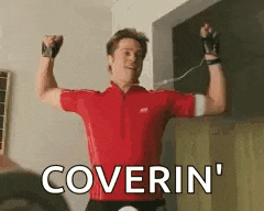 a man in a red shirt is flexing his muscles and the words coverin ' are visible in the background .