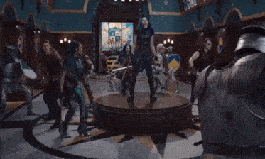 a group of knights in armor are standing in a room with stained glass windows