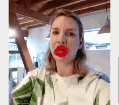 a woman with red lips on her face is wearing a green and white floral shirt .