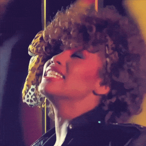 a woman with curly hair wearing a leopard print headband