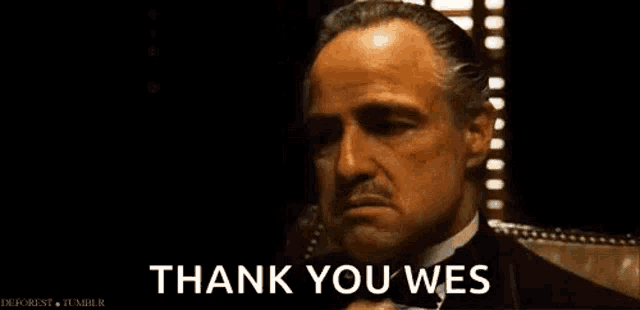 a man in a tuxedo is talking on a cell phone and saying `` thank you wes '' .
