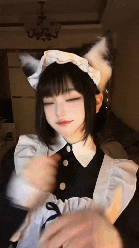 a girl in a maid costume with a cat ear headband is dancing .