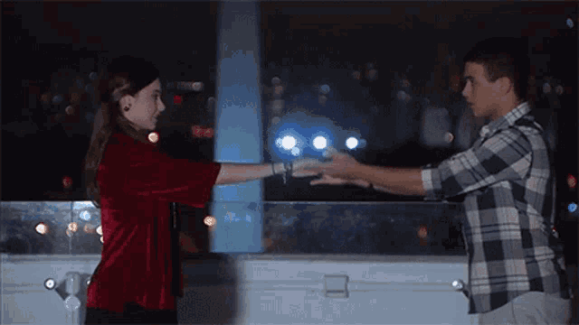 a man and a woman are holding hands in a dark room