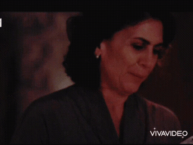 a woman is crying while holding a piece of paper in her hand