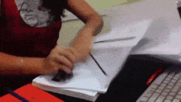 a woman is sitting at a desk with papers and a pen