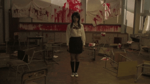 a girl in a white shirt and black skirt stands in a classroom