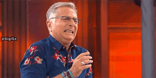 a man wearing glasses and a floral shirt is making a funny face .