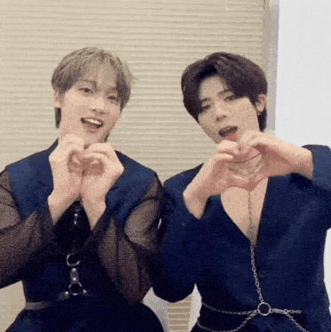 two men are making hearts with their hands