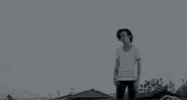 a black and white photo of a person standing in a field .