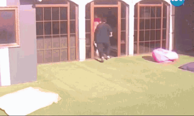 a man is walking through a doorway with a blue sign above him that says ' ntv '