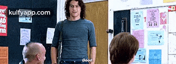 a man is standing in front of a group of people in a room .