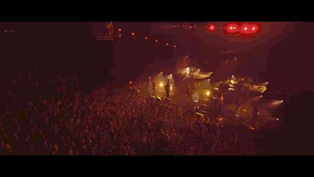 a crowd of people with their hands in the air at a concert