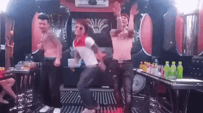 a group of men without shirts are dancing in a room .