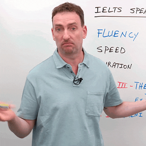 a man stands in front of a white board that says ielts speak