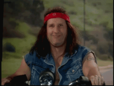 a man with long hair wearing a red bandana with the letter e on it