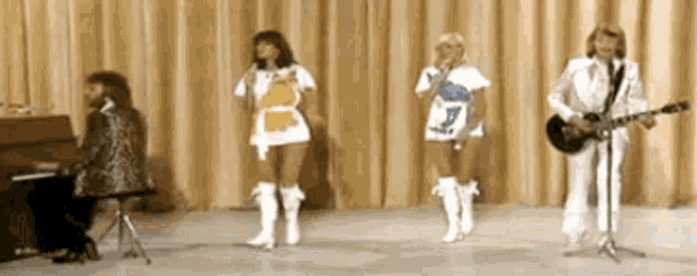 a group of people singing and playing instruments on stage