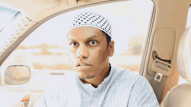 a man wearing a white hat and a blue shirt looks surprised