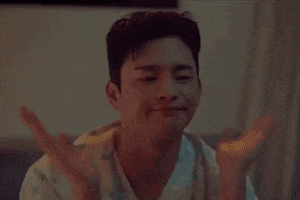 a man is sitting on a bed with his hands on his face and making a funny face .